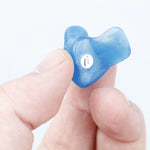 hand holding blue earplug with filter