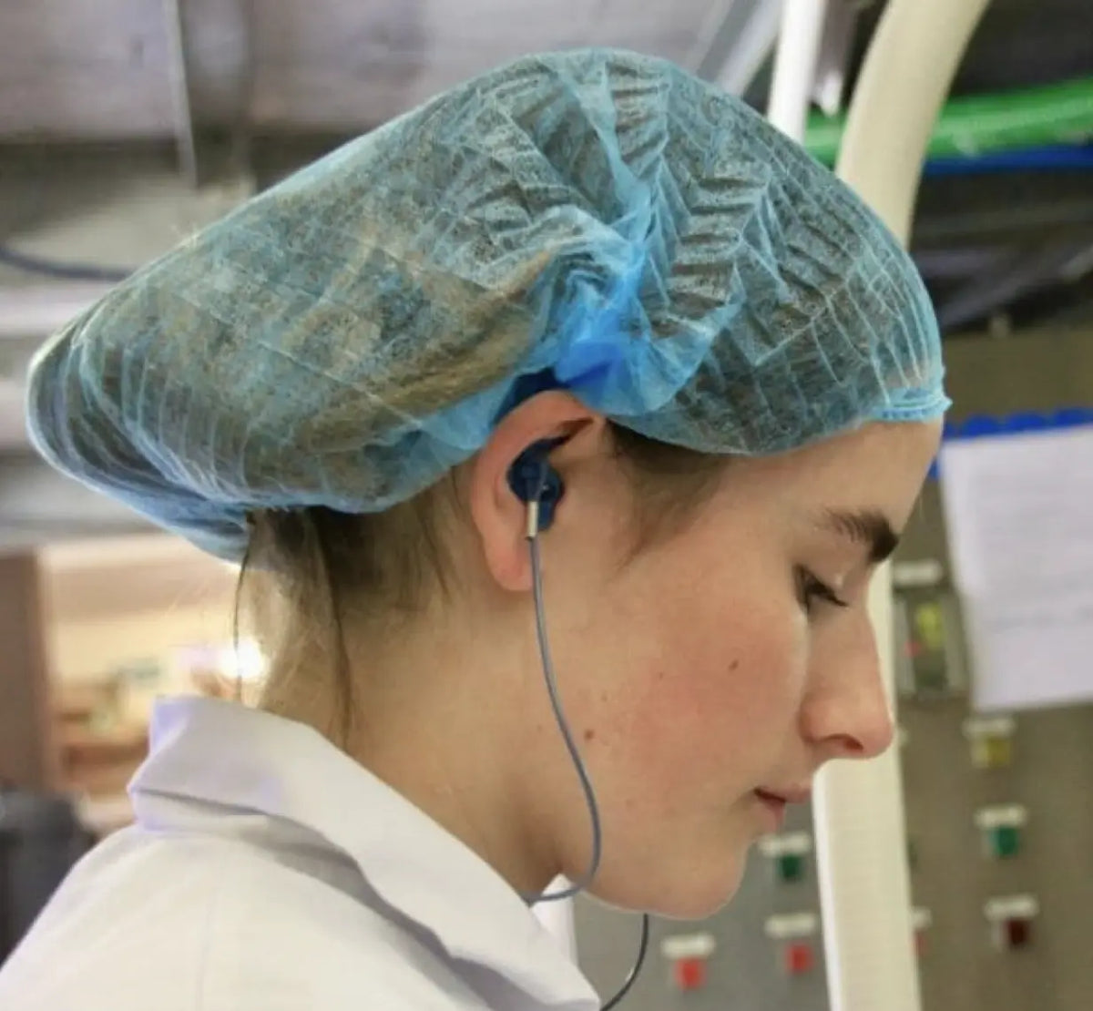 lady wearing blue coloured earplugs for food safety. 