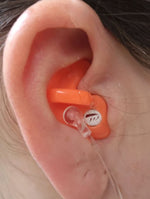 Orange earplug inside a person's ear