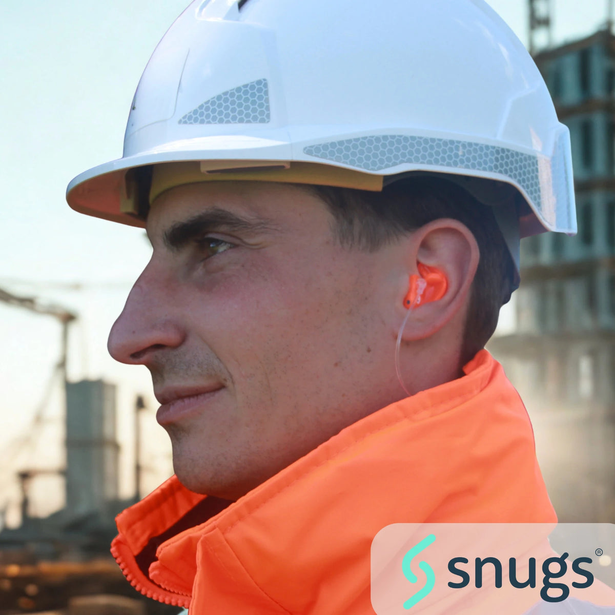 Person wearing a white hard hat and orange safety jacket with 'snugs' logo.